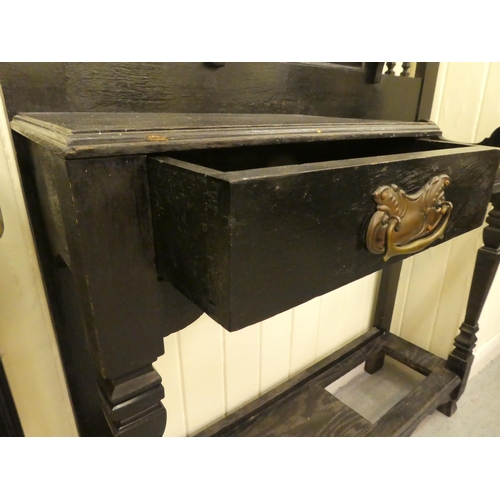 99 - A late Victorian black stained and carved oak hallstand, incorporating a bevelled mirror and an offs... 