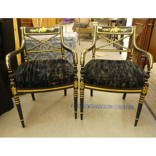 200 - A pair of Regency style black painted and gilt framed elbow chairs with crossover splats and open ar... 