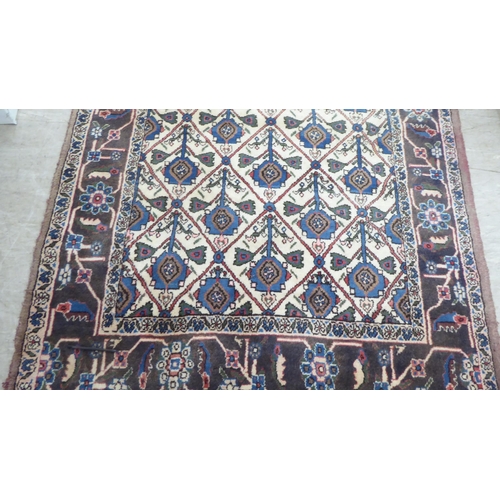 107 - A Persian rug, decorated with geometric elephant foot motifs, on a multi-coloured ground  54