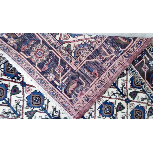 107 - A Persian rug, decorated with geometric elephant foot motifs, on a multi-coloured ground  54