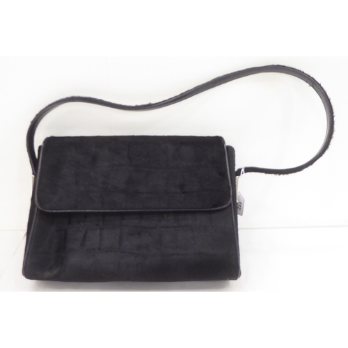 112 - A Gucci black fur covered handbag with a dust cover 