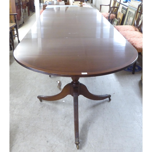 119 - A 20thC reproduction of a Regency crossbanded mahogany triple pedestal dining table with two additio... 