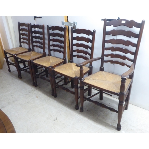 124 - A set of five 20thC Lancashire style, stained beech framed ladderback dining chairs, the rush seats ... 