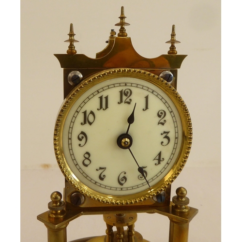 132 - An early 20thC lacquered brass torsion timepiece; faced by an Arabic dial, under a glass dome  8