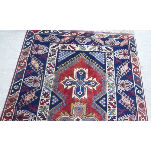 158 - A Persian rug, decorated with a central triple gul, on a red and blue ground  49