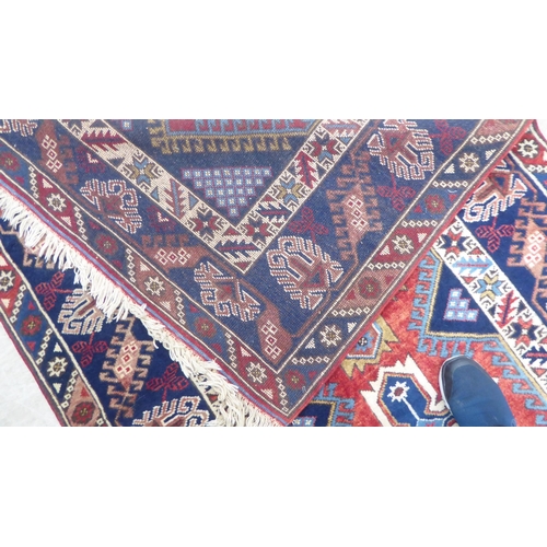 158 - A Persian rug, decorated with a central triple gul, on a red and blue ground  49