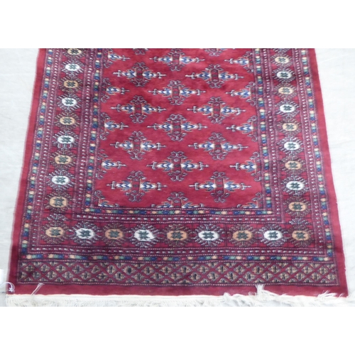 162 - A Persian rug, decorated with geometric motifs, on a red ground  63