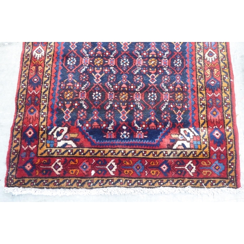 167 - A Persian runner, decorated with geometric motifs, on a red and blue ground  140