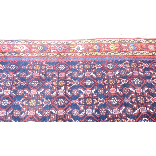 167 - A Persian runner, decorated with geometric motifs, on a red and blue ground  140