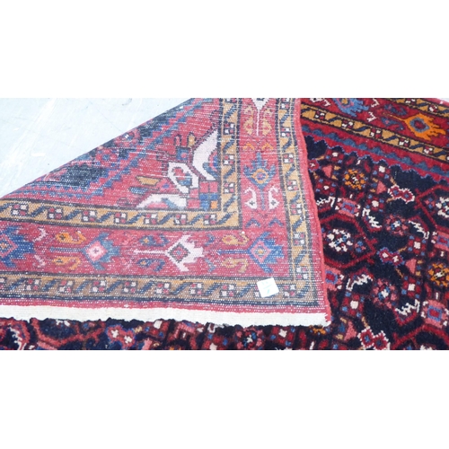 167 - A Persian runner, decorated with geometric motifs, on a red and blue ground  140