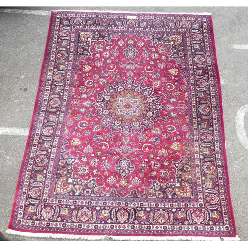 168 - An Iranian rug, decorated with ornate designs, on a red and blue ground  138