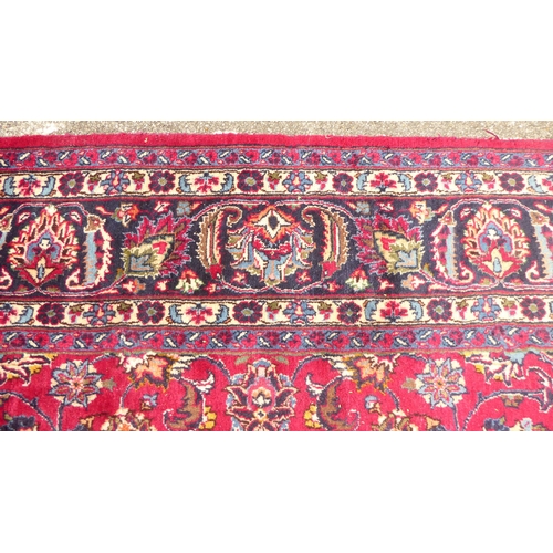 168 - An Iranian rug, decorated with ornate designs, on a red and blue ground  138