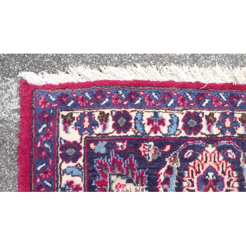 168 - An Iranian rug, decorated with ornate designs, on a red and blue ground  138