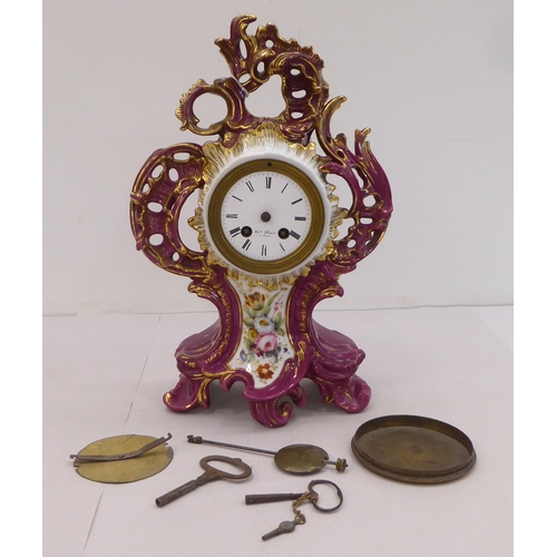 169 - A mid 20thC French mantel timepiece, , set in an ornate Rococo design china and floral overpainted c... 