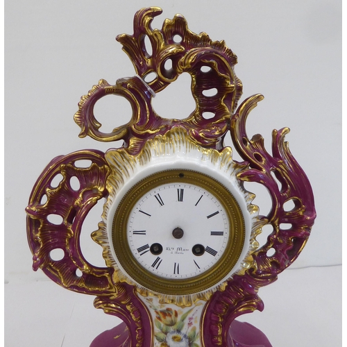 169 - A mid 20thC French mantel timepiece, , set in an ornate Rococo design china and floral overpainted c... 