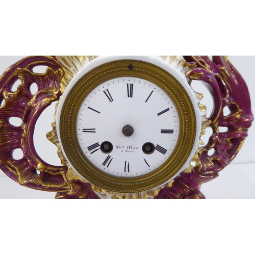 169 - A mid 20thC French mantel timepiece, , set in an ornate Rococo design china and floral overpainted c... 