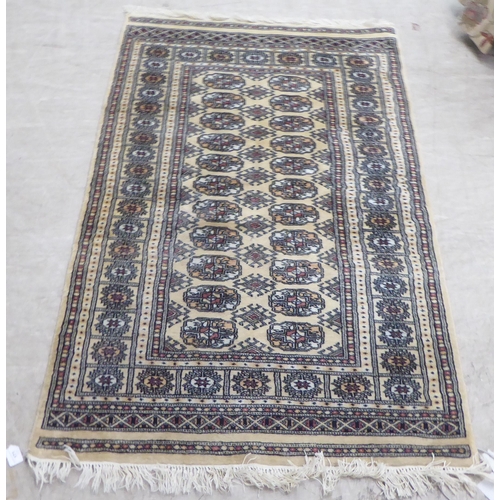 171 - A Bokhara rug, decorated with elephant foot motifs, on a beige and blue ground  60