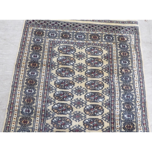 171 - A Bokhara rug, decorated with elephant foot motifs, on a beige and blue ground  60