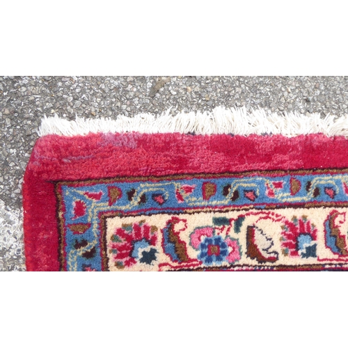 172 - A Persian rung, decorated with floral motifs, on red and blue  138