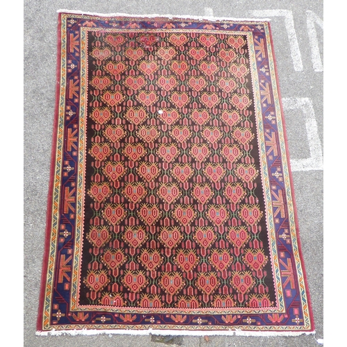 173 - A Persian rug, decorated with geometric motifs, on a dark blue ground  120