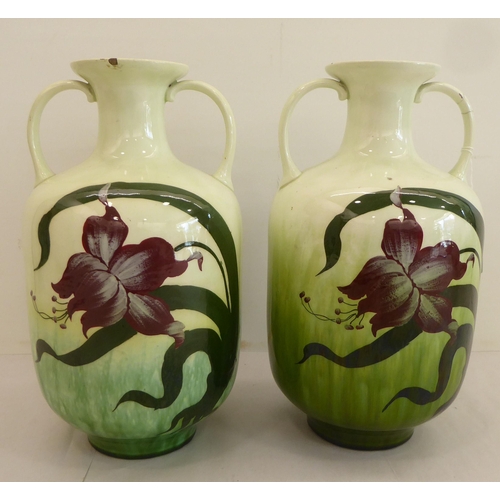 181 - A pair of early 20thC Austrian earthenware vases, decorated with Art Nouveau style flora  11.5