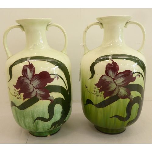 181 - A pair of early 20thC Austrian earthenware vases, decorated with Art Nouveau style flora  11.5