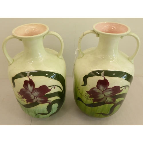 181 - A pair of early 20thC Austrian earthenware vases, decorated with Art Nouveau style flora  11.5