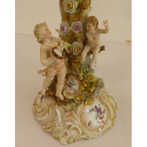 186 - A pair of late 19thC Continental porcelain triple branch candelabra, each fashioned as a tree, surmo... 