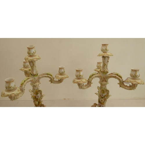 186 - A pair of late 19thC Continental porcelain triple branch candelabra, each fashioned as a tree, surmo... 