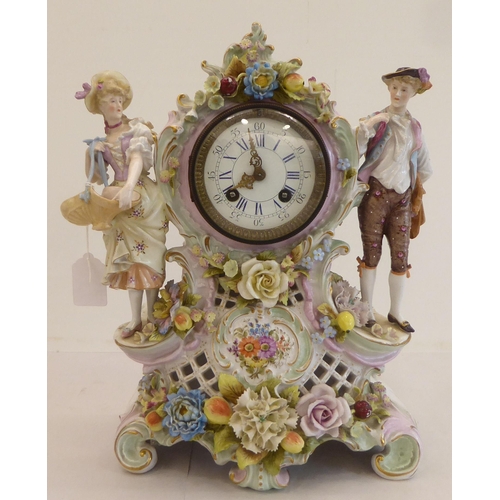 191 - A late 19thC Continental porcelain mantel clock, encrusted with flowers and fruit, surmounted by a m... 