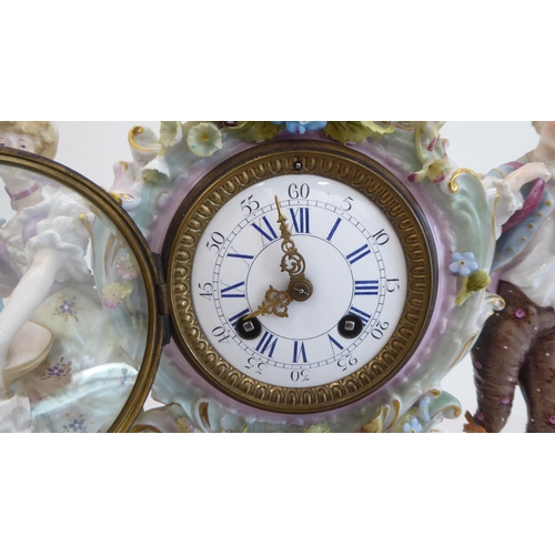 191 - A late 19thC Continental porcelain mantel clock, encrusted with flowers and fruit, surmounted by a m... 