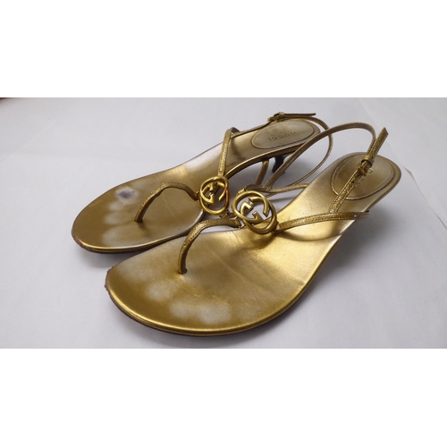 24 - A pair of ladies Gucci rubbed rose gold effect leather, low heeled, open toe shoes  size 39.5 with a... 