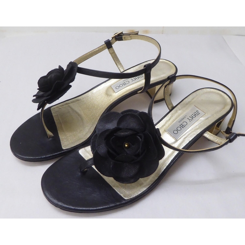 29 - A pair of ladies Jimmy Choo black leather, low heeled, open toe shoes with a floral motif  size 39.5... 