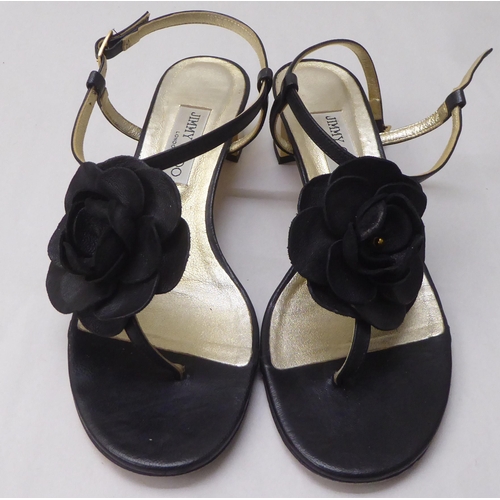 29 - A pair of ladies Jimmy Choo black leather, low heeled, open toe shoes with a floral motif  size 39.5... 