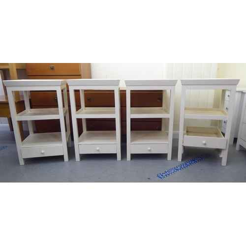 298 - A set of four modern cream painted, three tier occasional tables, raised on square legs  28