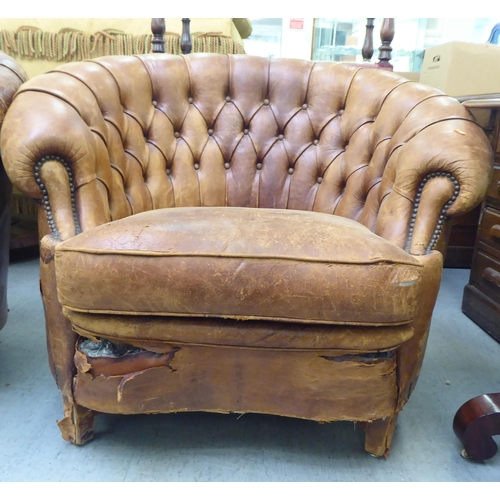 299 - A set of three early/mid 20thC stud and part button upholstered simulated brown hide armchairs, rais... 