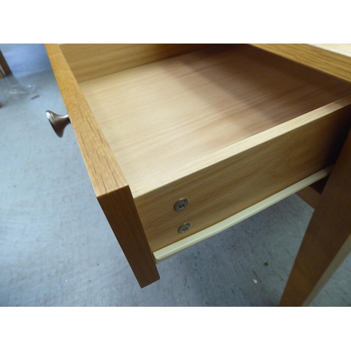 302 - A pair of modern light oak single drawer lamp tables, raised on square, tapered legs  20