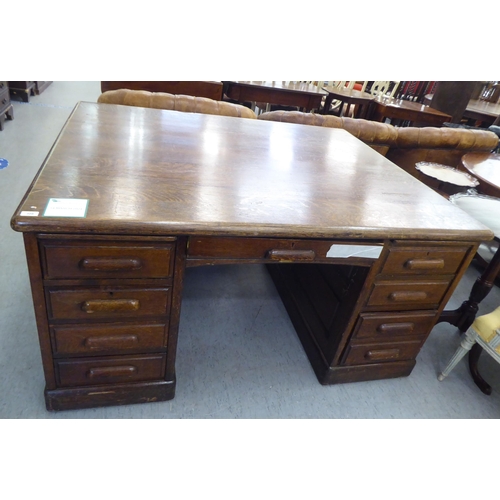 308 - A 1930s oak one piece eighteen drawer, twin pedestal partners desk, on a plinth&nbsp; 31