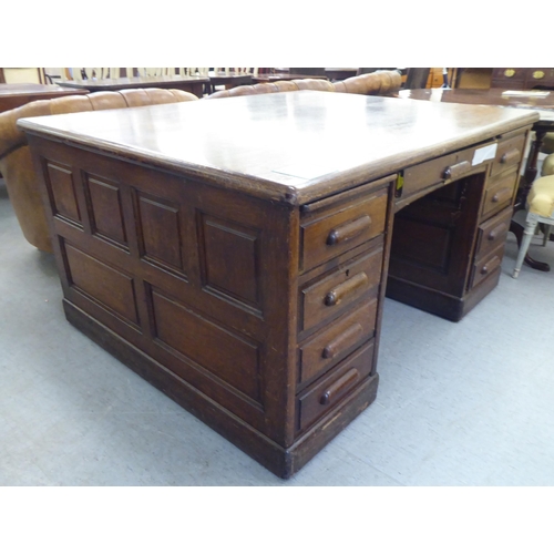 308 - A 1930s oak one piece eighteen drawer, twin pedestal partners desk, on a plinth&nbsp; 31