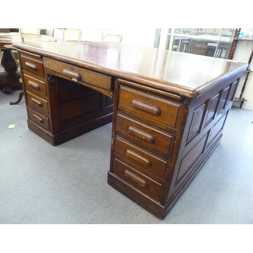 308 - A 1930s oak one piece eighteen drawer, twin pedestal partners desk, on a plinth&nbsp; 31