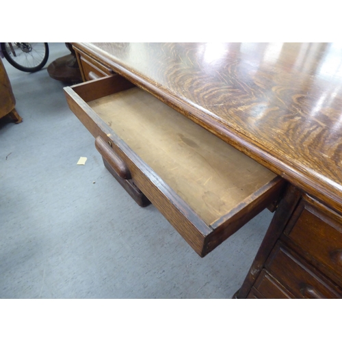 308 - A 1930s oak one piece eighteen drawer, twin pedestal partners desk, on a plinth&nbsp; 31
