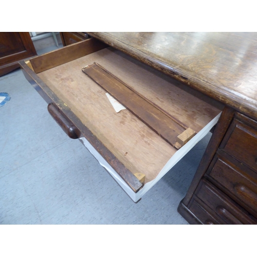 308 - A 1930s oak one piece eighteen drawer, twin pedestal partners desk, on a plinth&nbsp; 31