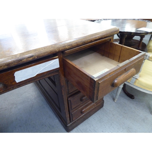 308 - A 1930s oak one piece eighteen drawer, twin pedestal partners desk, on a plinth&nbsp; 31