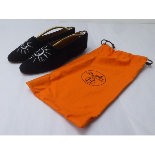 31 - A pair of ladies Hermes black suede pumps with stitched sun motifs  size 38.5 with a an orange dust ... 