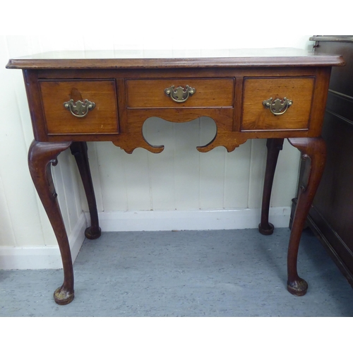 310 - A late 19thC walnut and mahogany three drawer lowboy, raised on tapered legs and pad feet&nbsp; 29