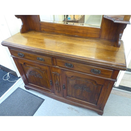 311 - An Edwardian mahogany dresser, the superstructure with a mirrored panel, two open shelves, over two ... 
