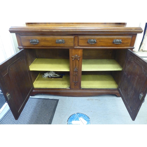 311 - An Edwardian mahogany dresser, the superstructure with a mirrored panel, two open shelves, over two ... 