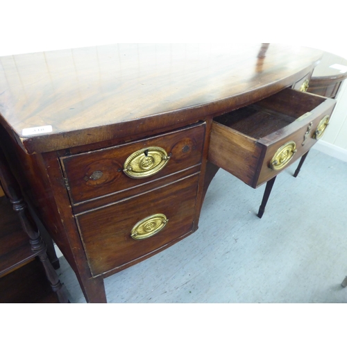 318 - A George III mahogany bow front sideboard with a central drawer, flanked by two cupboards, raised on... 