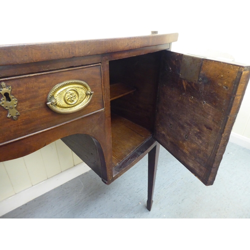 318 - A George III mahogany bow front sideboard with a central drawer, flanked by two cupboards, raised on... 