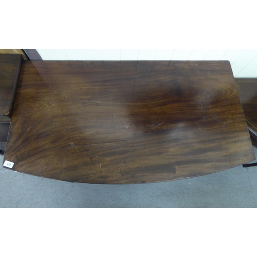 318 - A George III mahogany bow front sideboard with a central drawer, flanked by two cupboards, raised on... 